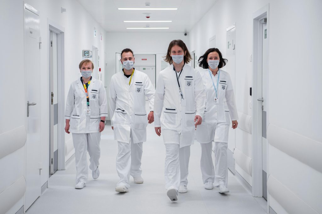 Medical team walking confidently in a hospital corridor, wearing face masks and white coats, symbolizing teamwork and healthcare dedication.