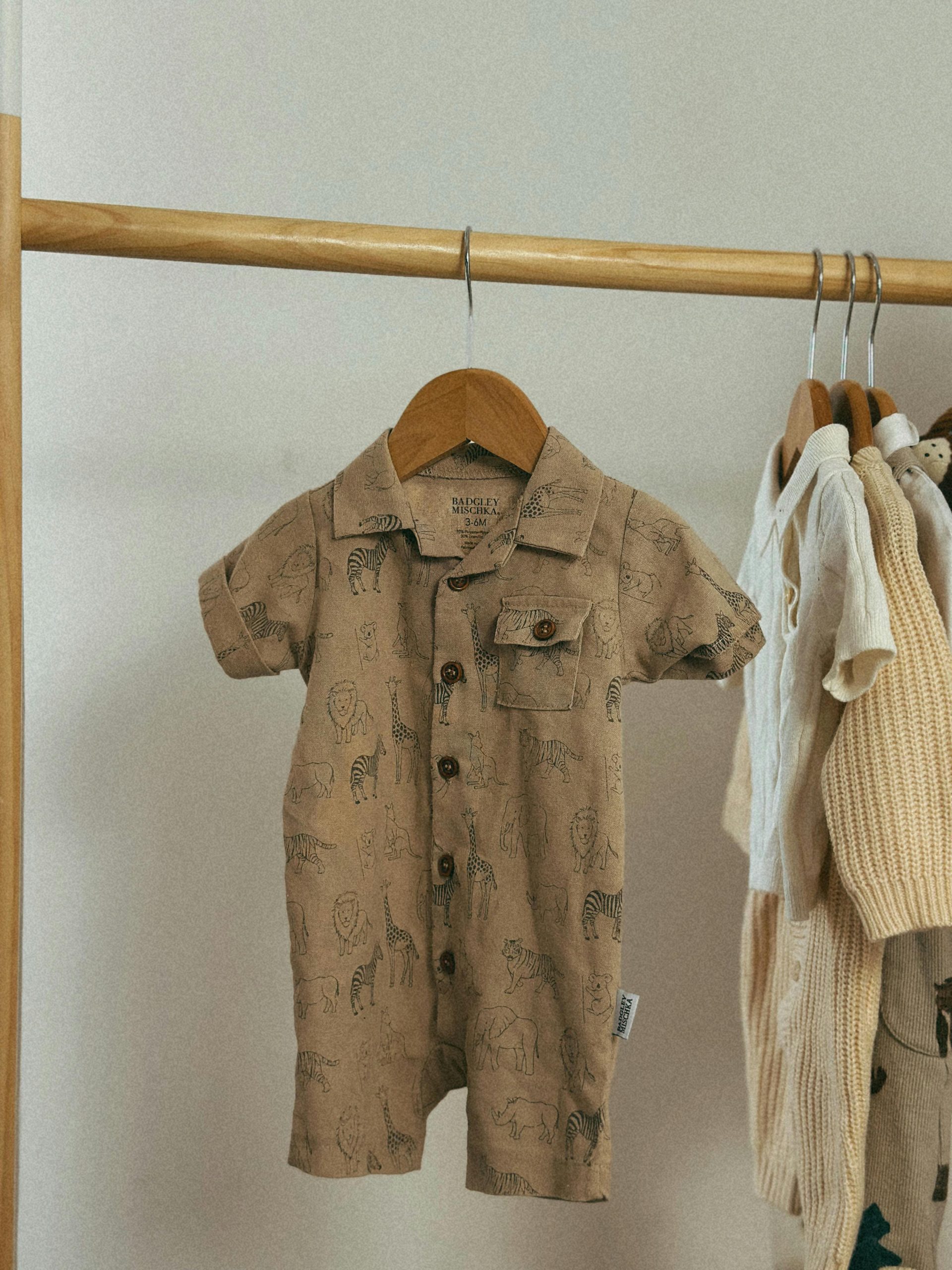 Adorable baby romper with animal prints in a cozy indoor setting.