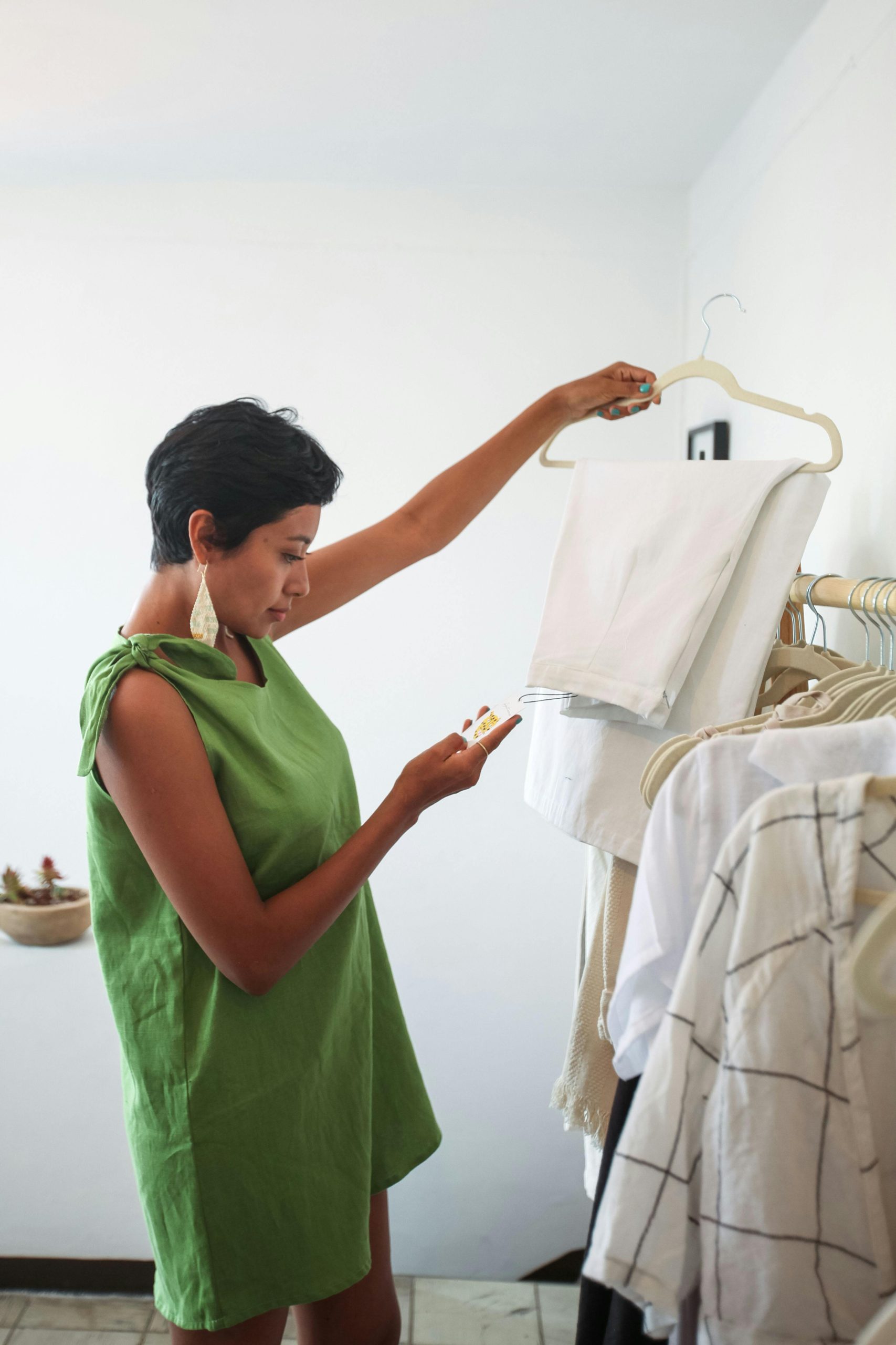 Woman examines clothes while shopping in a fashionable boutique.